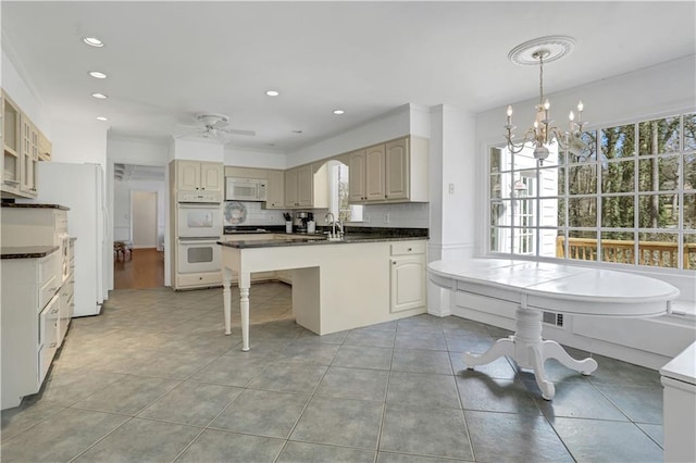 kitchen featuring white appliances, light tile patterned floors, sink, pendant lighting, and decorative backsplash