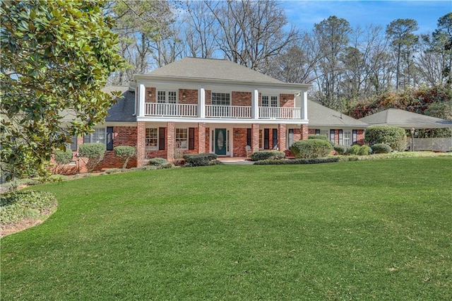 view of front of house featuring a front yard and a balcony