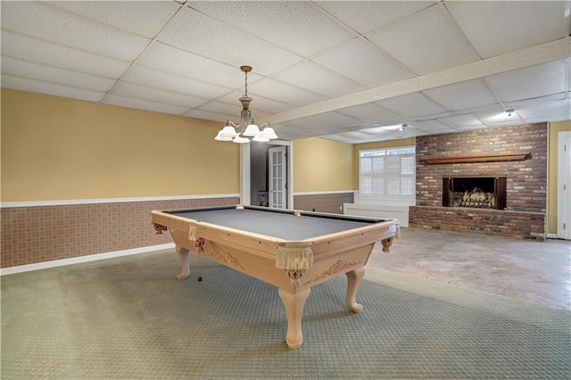 game room with pool table, a paneled ceiling, carpet floors, and a brick fireplace