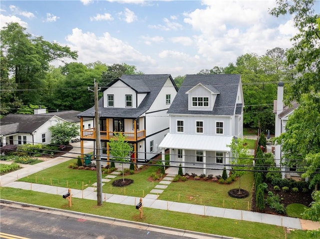 view of front of home with roof with shingles and a front lawn