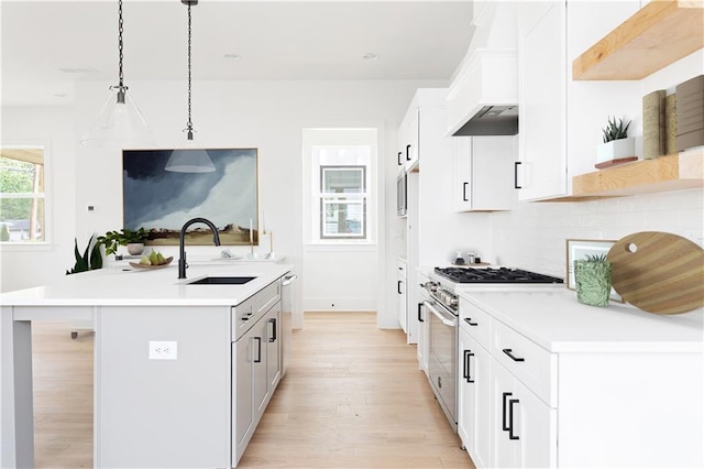 kitchen featuring a sink, light countertops, stainless steel appliances, and light wood-style flooring