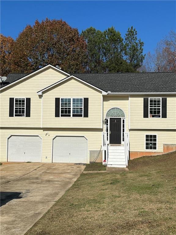 bi-level home featuring a front yard and a garage