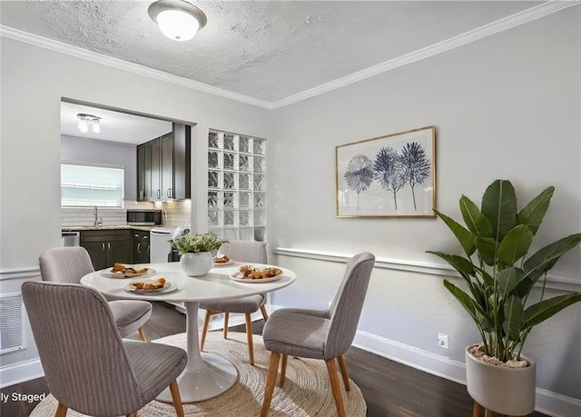 dining room with crown molding, sink, dark wood-type flooring, and a textured ceiling