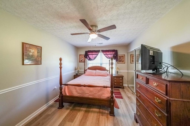 bedroom featuring ceiling fan, wood-type flooring, and a textured ceiling