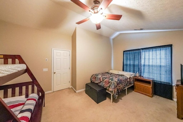 carpeted bedroom with a textured ceiling, vaulted ceiling, and ceiling fan