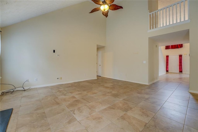 spare room featuring a ceiling fan, high vaulted ceiling, and baseboards