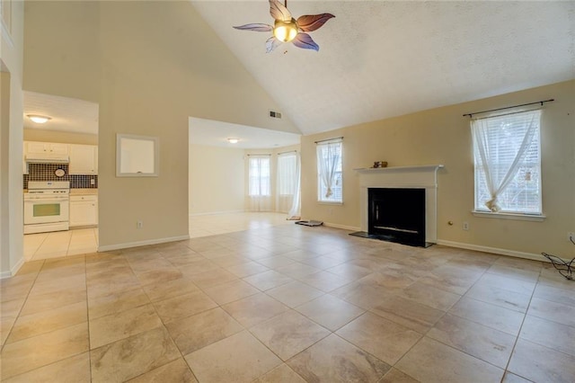 unfurnished living room with light tile patterned floors, baseboards, visible vents, a fireplace with raised hearth, and a ceiling fan