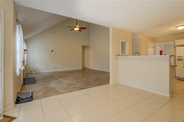 unfurnished living room with vaulted ceiling, light tile patterned flooring, ceiling fan, and baseboards