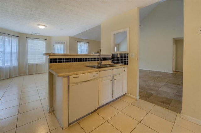 kitchen featuring light tile patterned floors, a sink, white cabinets, light countertops, and dishwasher