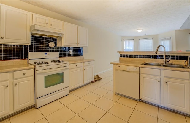 kitchen with backsplash, white cabinetry, a sink, white appliances, and premium range hood