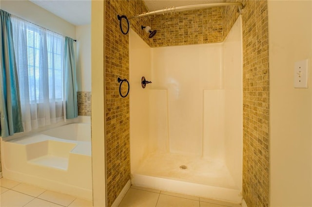 bathroom featuring a garden tub, a shower stall, and tile patterned floors