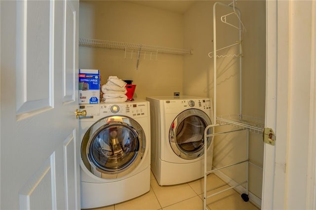 laundry area featuring light tile patterned floors, laundry area, and washing machine and dryer