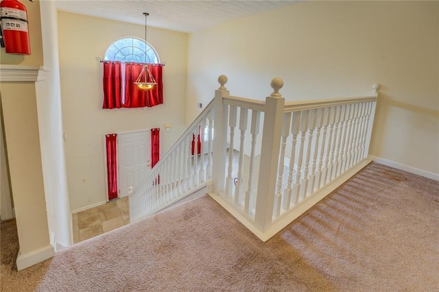 stairway featuring carpet floors and baseboards