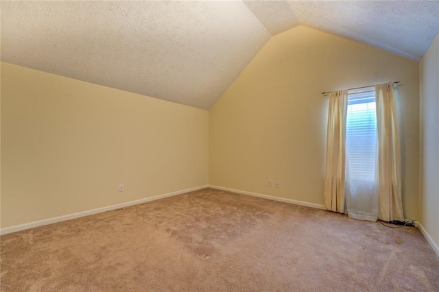 bonus room featuring lofted ceiling, light colored carpet, a textured ceiling, and baseboards