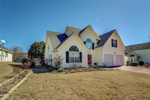 view of front of home with driveway, an attached garage, fence, and a front yard