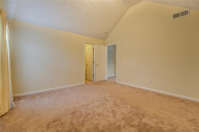 unfurnished room featuring light carpet, baseboards, visible vents, a textured ceiling, and high vaulted ceiling