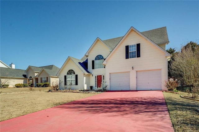 traditional-style house featuring a garage, driveway, and a front yard