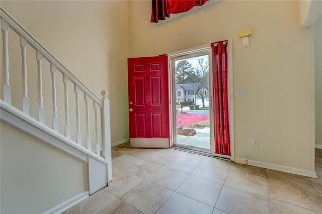 entryway featuring baseboards, stairway, and tile patterned floors