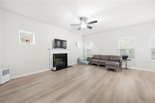 living room with radiator, light hardwood / wood-style floors, and ceiling fan