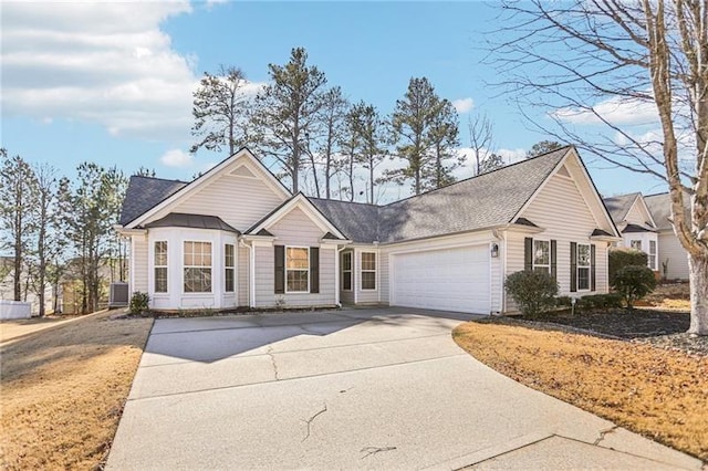 single story home with concrete driveway, a shingled roof, a garage, and cooling unit