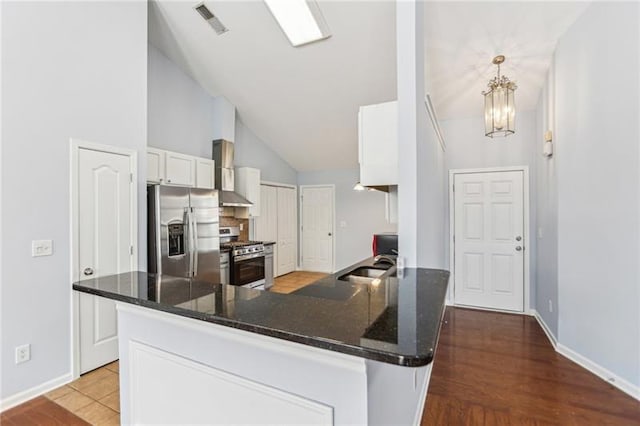 kitchen featuring a peninsula, visible vents, white cabinetry, baseboards, and appliances with stainless steel finishes