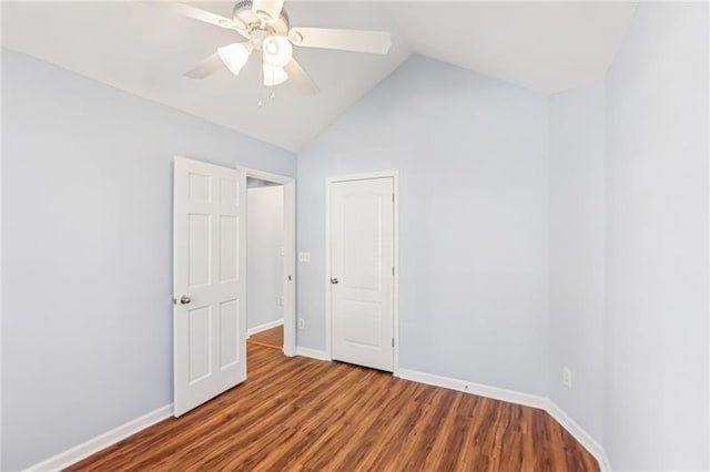 unfurnished bedroom featuring baseboards, lofted ceiling, ceiling fan, and wood finished floors
