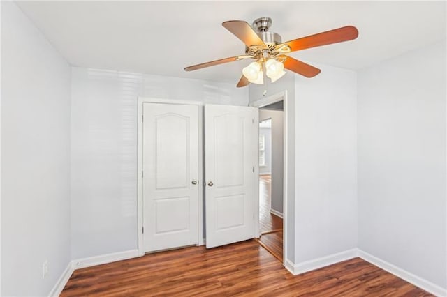 unfurnished bedroom with baseboards, a ceiling fan, and wood finished floors