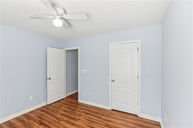 unfurnished bedroom featuring wood finished floors, baseboards, and a ceiling fan