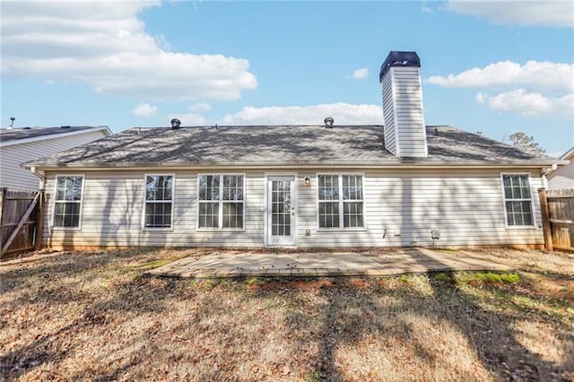 rear view of house with a fenced backyard, a patio area, and a chimney