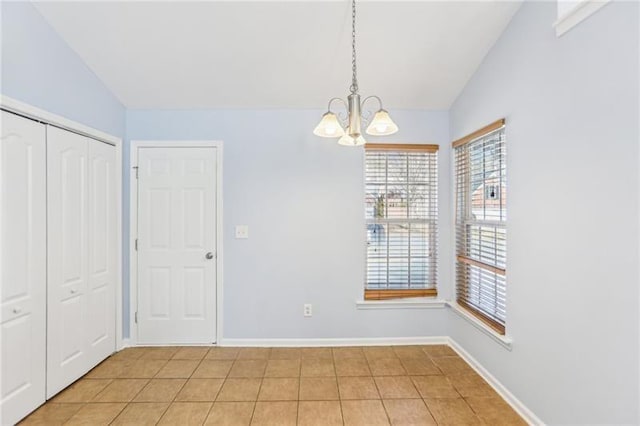 unfurnished dining area with light tile patterned floors, a notable chandelier, baseboards, and vaulted ceiling