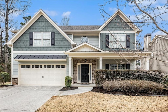 craftsman inspired home featuring a garage, concrete driveway, a standing seam roof, covered porch, and brick siding