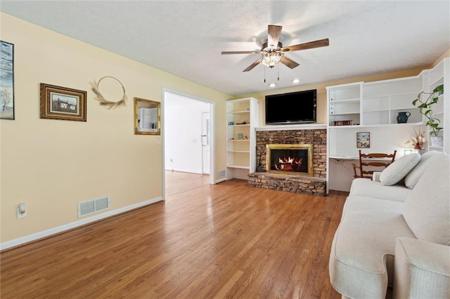 86 Sleepy Hollow Rd, Dahlonega, GA 30533 - living room featuring a ceiling fan, light wood-style floors, and a stone fireplace