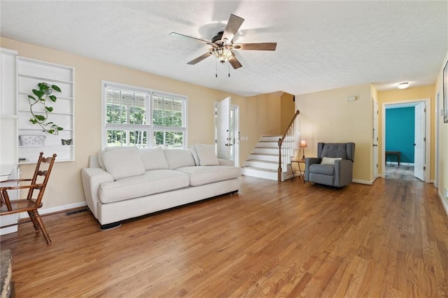 86 Sleepy Hollow Rd, Dahlonega, GA 30533 - living area featuring light wood finished floors, a textured ceiling, a ceiling fan, and stairway