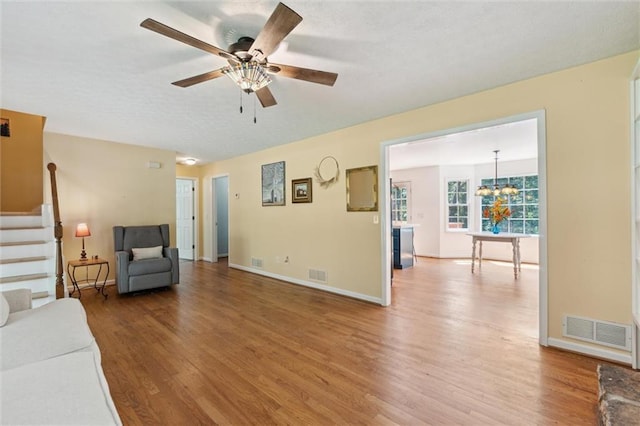 86 Sleepy Hollow Rd, Dahlonega, GA 30533 - unfurnished living room with wood finished floors, stairs, a ceiling fan, and a chandelier
