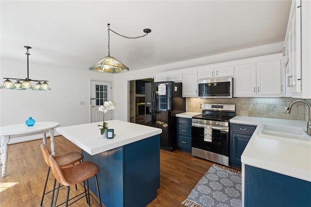 86 Sleepy Hollow Rd, Dahlonega, GA 30533 - kitchen with appliances with stainless steel finishes, blue cabinetry, light countertops, a center island, and decorative backsplash