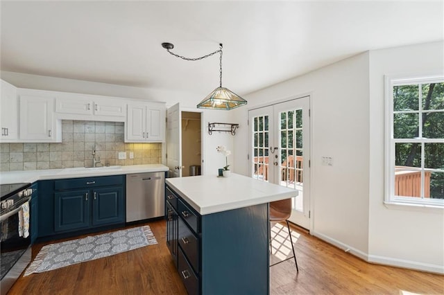 86 Sleepy Hollow Rd, Dahlonega, GA 30533 - kitchen with stainless steel appliances, blue cabinets, a breakfast bar, wood finished floors, and light countertops
