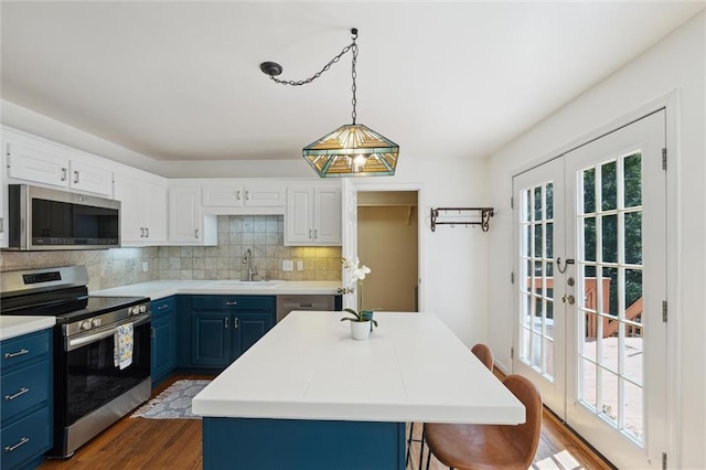 86 Sleepy Hollow Rd, Dahlonega, GA 30533 - kitchen featuring stainless steel appliances, blue cabinetry, dark wood-style flooring, tasteful backsplash, and a breakfast bar
