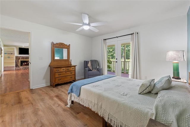 86 Sleepy Hollow Rd, Dahlonega, GA 30533 - bedroom featuring access to exterior, french doors, light wood-type flooring, a lit fireplace, and ceiling fan