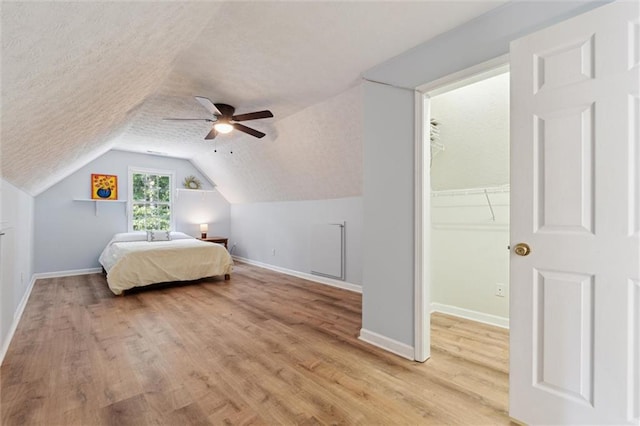 86 Sleepy Hollow Rd, Dahlonega, GA 30533 - bedroom with a walk in closet, light wood-type flooring, vaulted ceiling, ceiling fan, and a closet