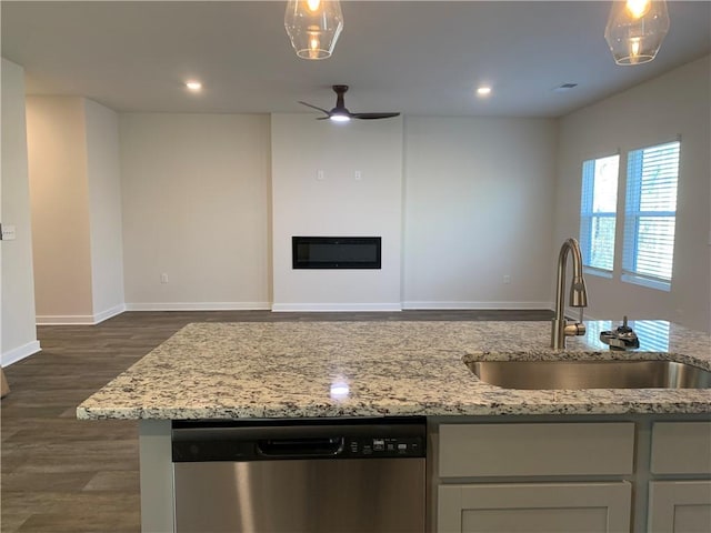 kitchen featuring dark wood-type flooring, sink, light stone counters, dishwasher, and ceiling fan