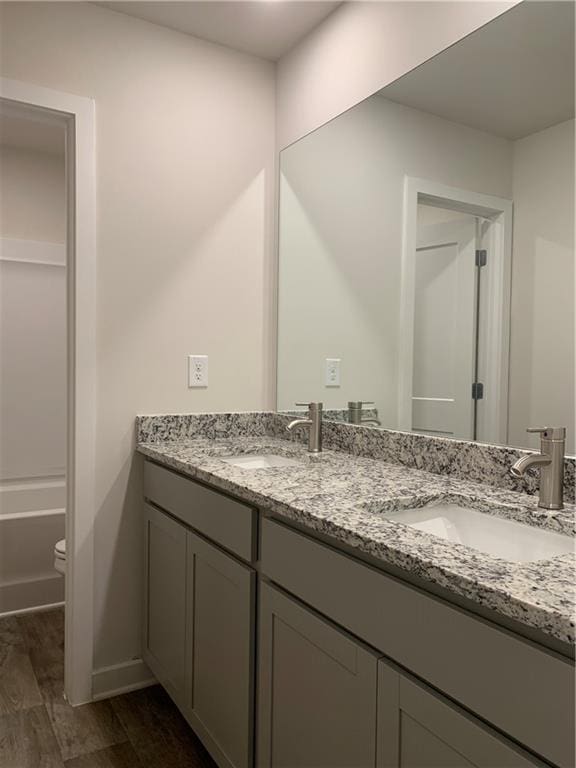 bathroom featuring vanity, hardwood / wood-style floors, and toilet