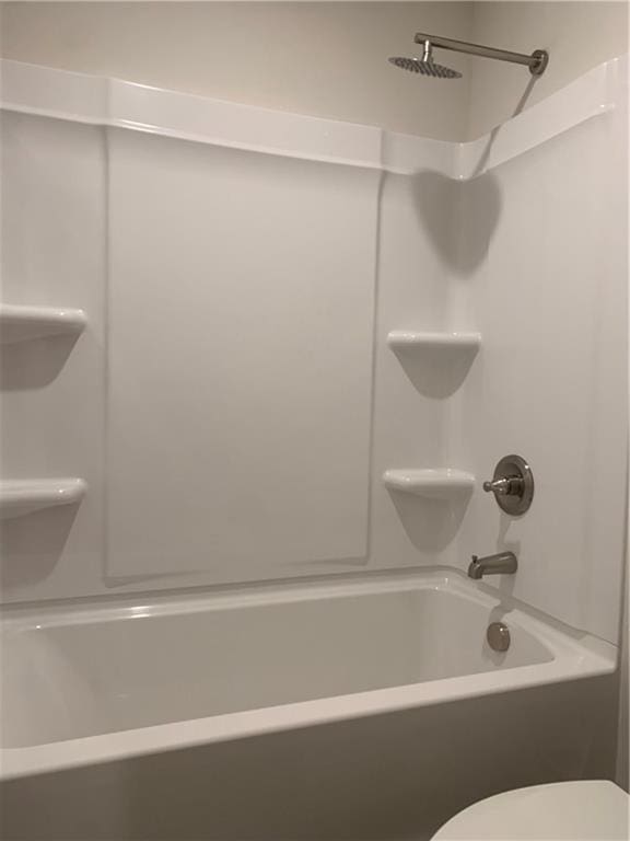 bathroom featuring bathing tub / shower combination and toilet