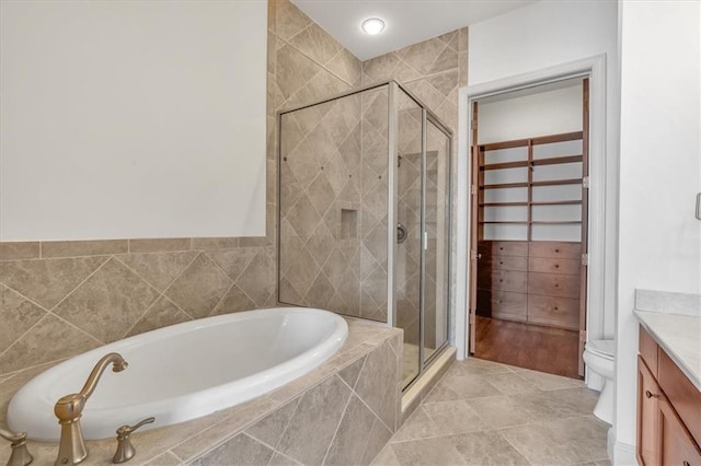 full bathroom with vanity, shower with separate bathtub, and toilet