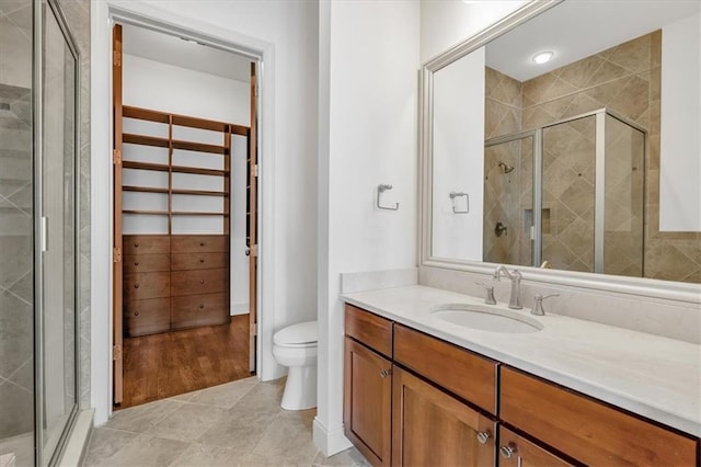 bathroom featuring vanity, tile patterned flooring, toilet, and walk in shower