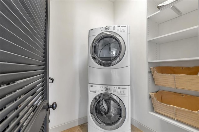 laundry room featuring light tile patterned flooring and stacked washer and clothes dryer