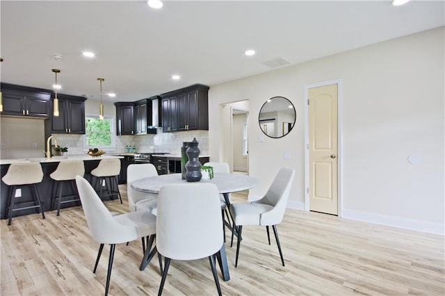 dining space with sink and light hardwood / wood-style flooring