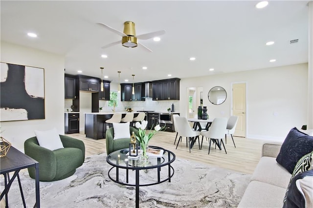 living room featuring light hardwood / wood-style floors and ceiling fan