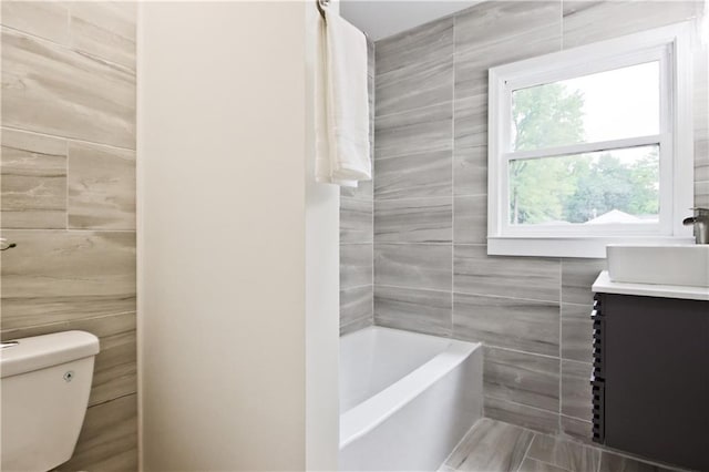 bathroom with vanity, toilet, and tile walls