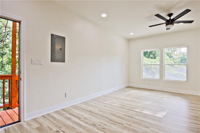 empty room with electric panel, ceiling fan, and light hardwood / wood-style flooring