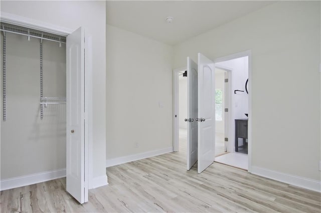 unfurnished bedroom featuring light wood-type flooring and a closet